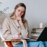 vrouw laptop stoel notities boek kaars