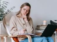 vrouw laptop stoel notities boek kaars