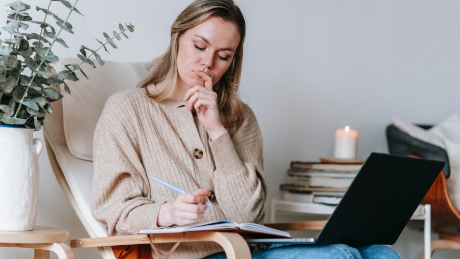 vrouw laptop stoel notities boek kaars